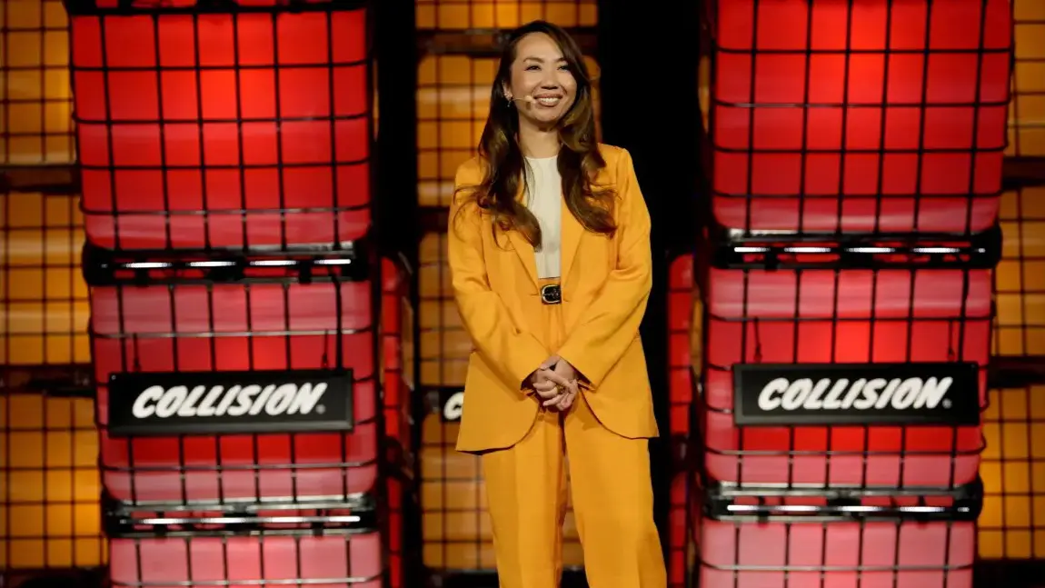 A woman in yellow suit standing on stage.