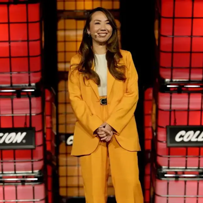 A woman in yellow suit standing on stage.