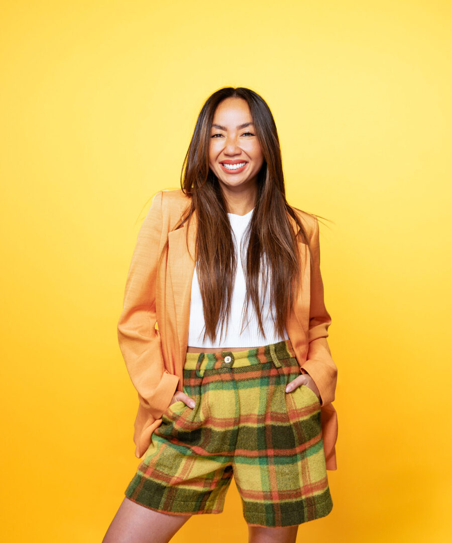 A woman in plaid pants and an orange jacket.