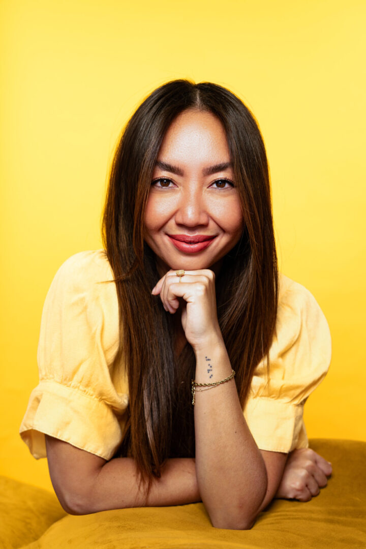 A woman with long hair and a yellow shirt