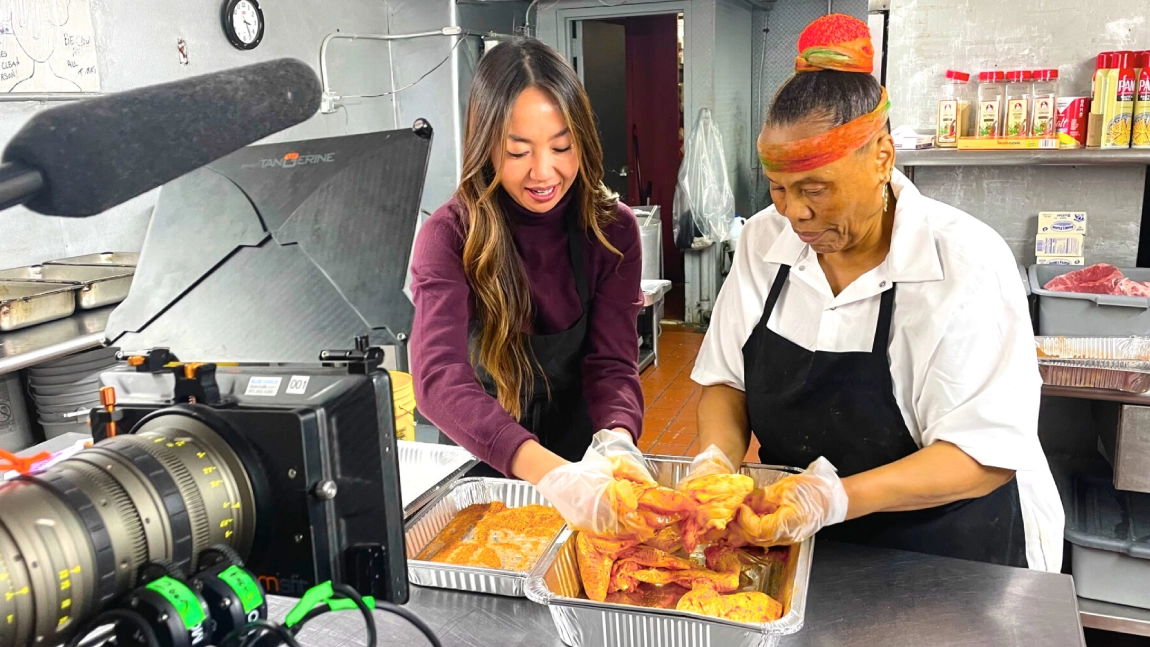 Two women are preparing food in a kitchen.